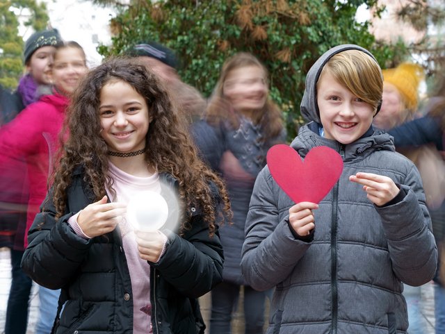 Zwei Schüler halten eine Glühbirne und ein Herz